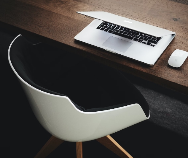 A chair, desk and laptop.