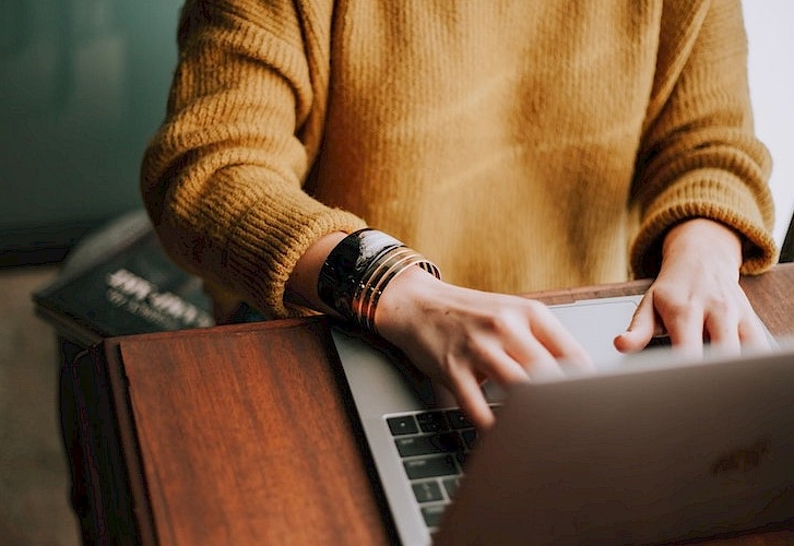 Woman typing on a laptop.